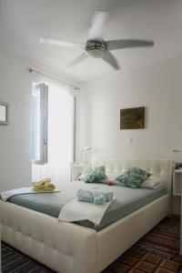 een slaapkamer met een groot bed met een plafondventilator bij Vila Vinci 1906 in Vrsar