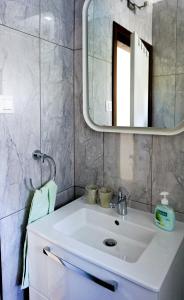 een badkamer met een witte wastafel en een spiegel bij Vila Vinci 1906 in Vrsar