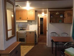 a kitchen with wooden cabinets and a table and a dining room at Rooms for Rent near Vilnius in Bezdonys