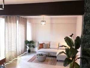 un salon avec un canapé et une plante en pot dans l'établissement Appartement Carré d'Or Vue sur Mer, à Nice