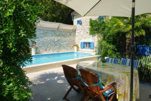 a table with chairs and an umbrella next to a pool at Vila Vinci 1906 in Vrsar