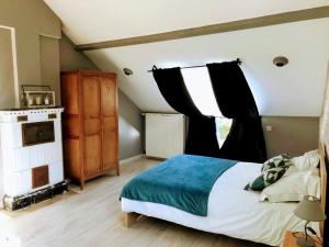 a bedroom with a large bed and a fireplace at La Marelle in Avrillé-les-Ponceaux