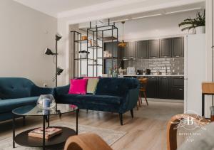uma sala de estar com um sofá azul e uma mesa em Heart of the City - Better Stay Townhouse em Ruse
