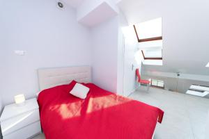 a bedroom with a red bed with a red blanket at Exclusive Loft in the Main Square A/C p4you pl in Krakow