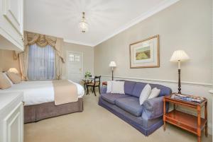 a hotel room with a bed and a couch at 44 Curzon Street by Mansley in London