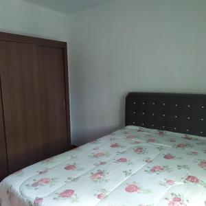 a bedroom with a bed with a floral bedspread at Quarto duplo aconchegante com banheiro privativo, ambiente inteiro in Barueri