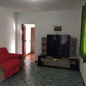 a living room with a couch and a flat screen tv at Quarto duplo aconchegante com banheiro privativo, ambiente inteiro in Barueri