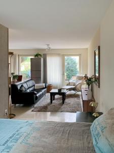 a living room with a black leather couch and a living room with a couch at Kluiskade 24 Maasland in Maasland