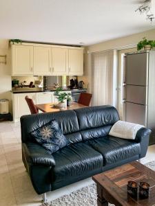 a black leather couch in a kitchen with a table at Kluiskade 24 Maasland in Maasland