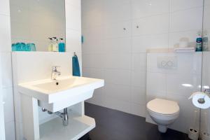 a white bathroom with a sink and a toilet at Bed & Breakfast Hotel Malts in Haarlem +48 photos