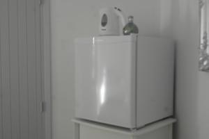 einen weißen Kühlschrank mit einer Flasche darüber in der Unterkunft Treasurita Guest House in Moraira