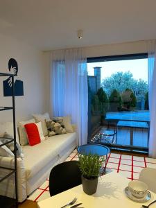 ein Wohnzimmer mit einem Sofa und einem großen Fenster in der Unterkunft Cozy RED BULLDOG Place in Apart-Complex/Pool in Warna