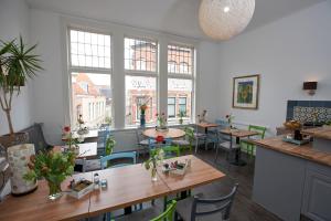 un restaurante con mesas, sillas y ventanas grandes en Bed & Breakfast Hotel Malts en Haarlem