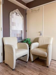 twee stoelen en een spiegel in een kamer bij Kluiskade 24 Maasland in Maasland