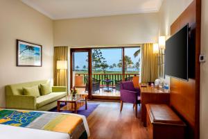 a hotel room with a bed and a living room at Caravela Beach Resort in Varca