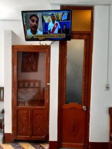 uma televisão de ecrã plano por cima de duas portas de uma casa em HOSPEDAJE CENTRAL em Ayacucho
