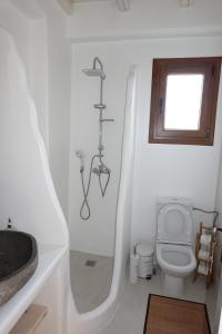 a white bathroom with a toilet and a sink at Divers House in Agrari
