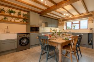 a kitchen with a wooden table and chairs at Field House Cottage in Weston Subedge
