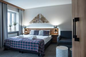 ein Hotelzimmer mit einem Bett und einem Stuhl in der Unterkunft Nowa - Ski SPA Hotel in Karpacz