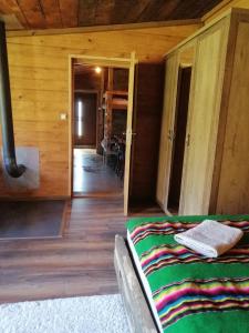 a bedroom with a bed in a room with wooden walls at Agroturystyka Wiski 66 in Wiski