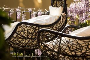 2 sillas con almohadas sentadas frente a flores púrpuras en L'Aromatario, en Neive