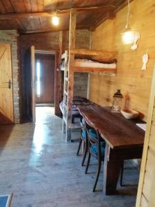 a room with a long wooden table and bunk beds at Agroturystyka Wiski 66 in Wiski