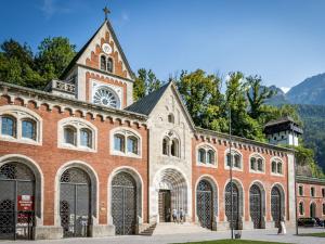 a large red brick building with a clock tower at Haus Alpenruhe in Bad Reichenhall