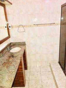 uma casa de banho com um lavatório e um chuveiro em Pousada 146 em Campos dos Goytacazes