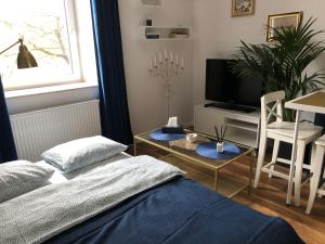 a bedroom with a bed and a table and a tv at Blue Dior Apartment Warsaw in Warsaw