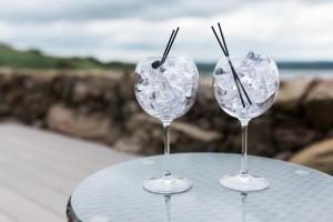 two wine glasses sitting on top of a table at Sea View Snugs at Laggan in Gatehouse of Fleet