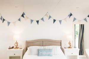 
a bed room with a white bedspread and a blue and white bed at Sea View Snugs at Laggan in Gatehouse of Fleet
