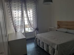 Schlafzimmer mit einem Bett und einem Fenster in der Unterkunft Bea's Apartment - The window to the sea - Seafront in Monterosso al Mare