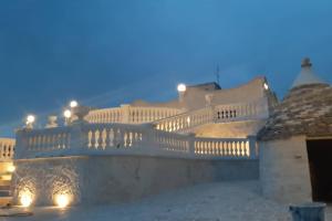 a white balcony with lights on it at night at Villa Clara in Alberobello