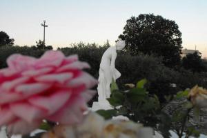 a statue of a woman in a garden with flowers at Villa Clara in Alberobello