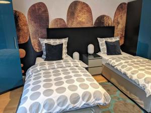 1 Schlafzimmer mit 2 Betten und einer Wand mit Spiegeln in der Unterkunft Apartment Blue Regensburg in Regensburg