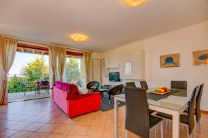 een woonkamer met een rode bank en een tafel bij Groppello in Polpenazze del Garda