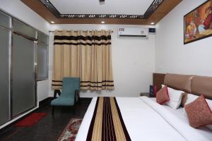 um quarto de hotel com uma cama e uma cadeira em JJK @ STAY HOME em Dehradun