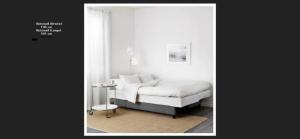 - une chambre blanche avec un lit et une table dans l'établissement Apartment Blue Regensburg, à Ratisbonne