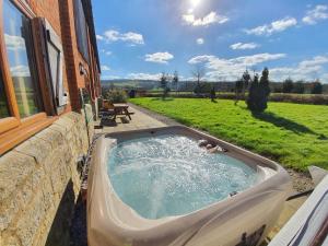 a bath tub on the side of a building at The Victorian Barn, Self-Catering Holidays with Pool and Hot Tubs, Dorset in Woolland
