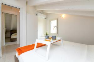 een witte slaapkamer met een wit bed en een tafel bij Villa Meri Star in Manerba del Garda