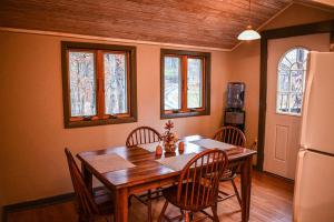 a dining room with a table and chairs and a refrigerator at Brook Road Cabin in Goshen