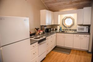 a kitchen with white appliances and a white refrigerator at Brook Road Cabin in Goshen