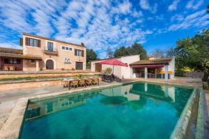 a swimming pool in front of a house at Finca Can Peixet in Manacor