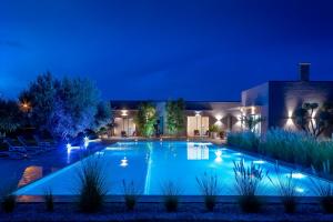una piscina notturna con luci di Villa Jardins D'Isa a Marrakech