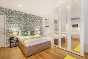 a bedroom with two beds and a large window at Marylebone - Crawford Street by Viridian Apartments in London