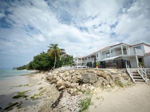 a house on the beach next to the water at Coco Beach Marie-Galante in Grand-Bourg