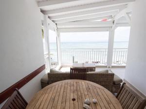 a balcony with a wooden table and a view of the ocean at Coco Beach Marie-Galante in Grand-Bourg