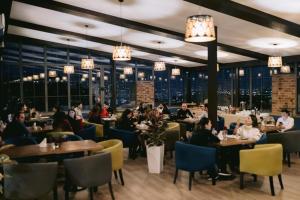 a group of people sitting at tables in a restaurant at 14 Floor Hotel in Yerevan