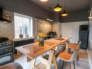 a kitchen with a table with flowers on it at The Pump House Art Studio in Gainsborough