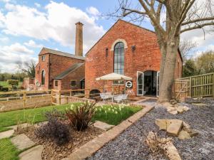 an exterior view of a brick church with a tree at The Pump House Art Studio in Gainsborough